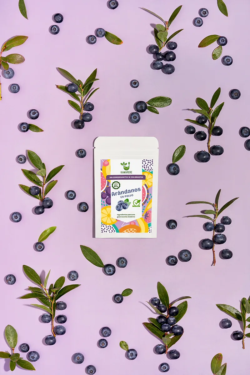 A commercial photograph of Kamarere’s 100% natural dehydrated fruit and vegetable powder in a resealable white pouch. The colorful label features a modern, vibrant fruit and vegetable pattern with the Kamarere logo at the top. The packaging highlights its preservative-free and additive-free composition, emphasizing its use for innovative cooking and gastronomy. The label includes an illustration representing fresh ingredients, reinforcing its natural origin.
