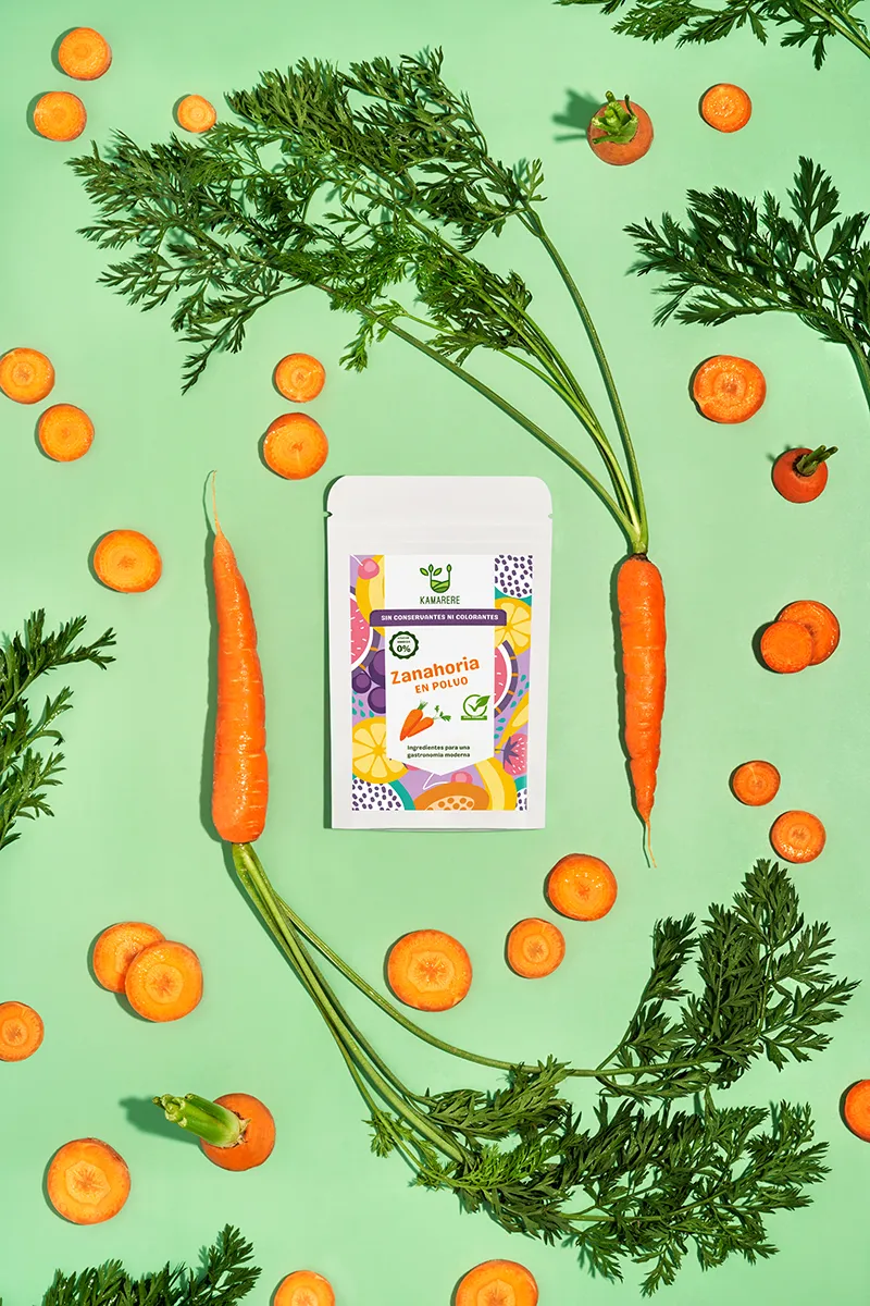 A commercial photograph of Kamarere’s 100% natural dehydrated fruit and vegetable powder in a resealable white pouch. The colorful label features a modern, vibrant fruit and vegetable pattern with the Kamarere logo at the top. The packaging highlights its preservative-free and additive-free composition, emphasizing its use for innovative cooking and gastronomy. The label includes an illustration representing fresh ingredients, reinforcing its natural origin.