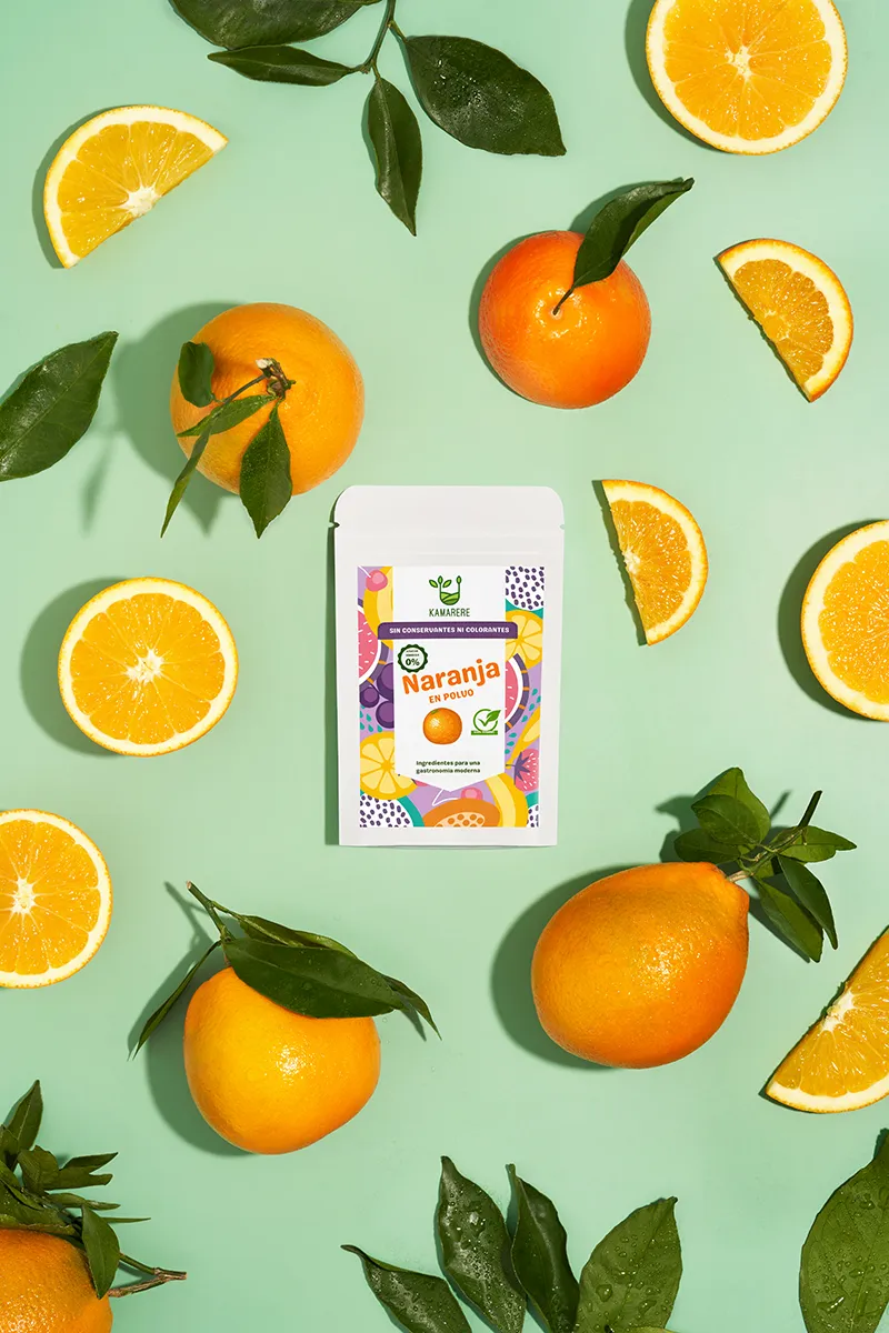 A commercial photograph of Kamarere’s 100% natural dehydrated fruit and vegetable powder in a resealable white pouch. The colorful label features a modern, vibrant fruit and vegetable pattern with the Kamarere logo at the top. The packaging highlights its preservative-free and additive-free composition, emphasizing its use for innovative cooking and gastronomy. The label includes an illustration representing fresh ingredients, reinforcing its natural origin.