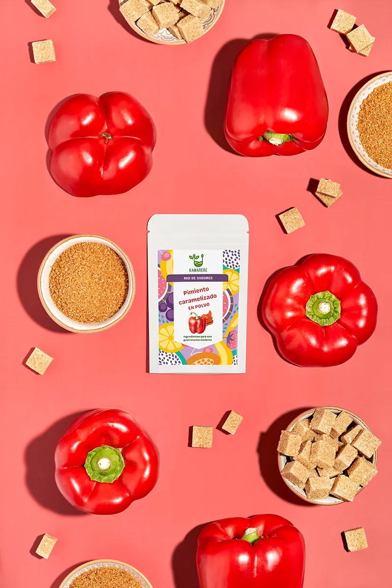 A commercial photograph of Kamarere’s 100% natural dehydrated fruit and vegetable powder in a resealable white pouch. The colorful label features a modern, vibrant fruit and vegetable pattern with the Kamarere logo at the top. The packaging highlights its preservative-free and additive-free composition, emphasizing its use for innovative cooking and gastronomy. The label includes an illustration representing fresh ingredients, reinforcing its natural origin.